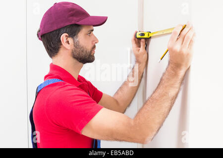 Construction worker using measuring tape Stock Photo