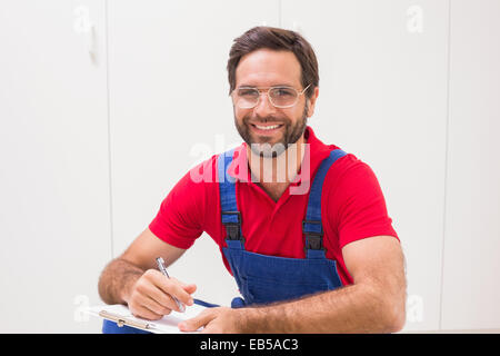 Construction worker taking notes on clipboard Stock Photo