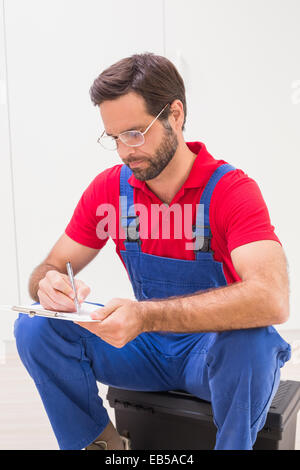Construction worker taking notes on clipboard Stock Photo