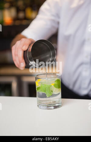Bartender pouring cocktail into glass Stock Photo