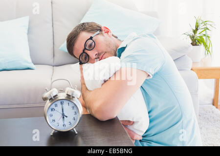 Bored man on the table beside alarm clock Stock Photo