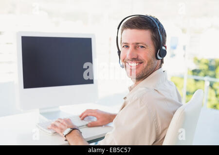 Businessman in headset smiling at camera Stock Photo