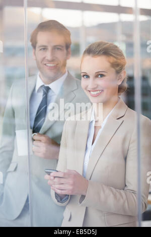 Business people looking at camera through the window Stock Photo