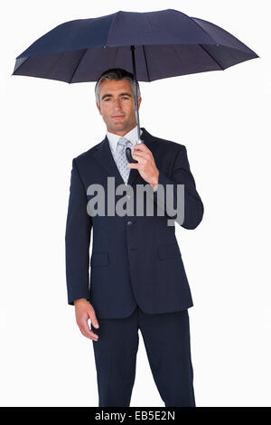 Cheerful businessman in suit under umbrella Stock Photo