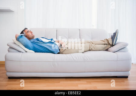 Smiling man lying and relaxing on the couch Stock Photo