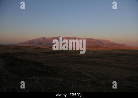 Brandberg Mountain glows red in the evening light at sunset, in Damaraland, northwestern Namib Desert, Namibia. Stock Photo