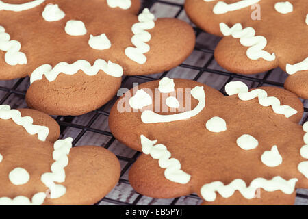 Freshly baked gingerbread man cookies on cooling rack, closeup Stock Photo