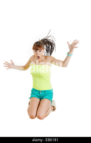 Shocked and surprised beautiful cute young woman or girl in blank green t-shirt and shorts jumps with face expression over white Stock Photo