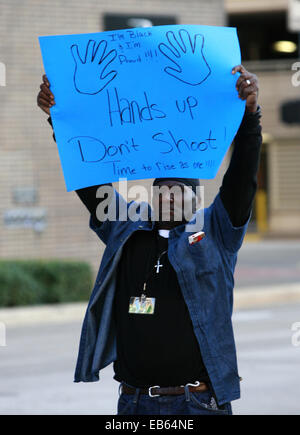 Houston, USA. 26th Nov, 2014. A protestor holding a poster is seen in Houston, the United States, Nov. 26, 2014. The National Black Unite Front held a protest against the Ferguson grand jury's decision not to indict a white police officer who killed an unarmed black teenager in August, in Houston on Wednesday. Credit:  Song Qiong/Xinhua/Alamy Live News Stock Photo