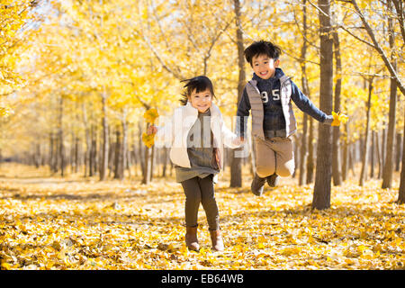 Two children playing in autumn woods Stock Photo