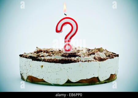 a birthday cake with a question mark shaped candle Stock Photo