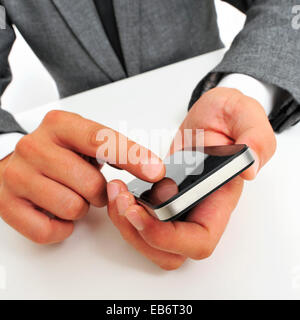 a businessman sitting in a table using a smartphone Stock Photo