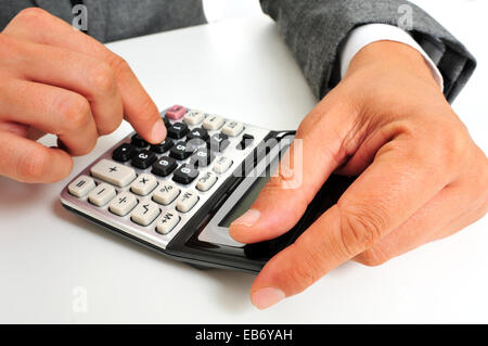 a businessman sitting in a desk using a calculator Stock Photo