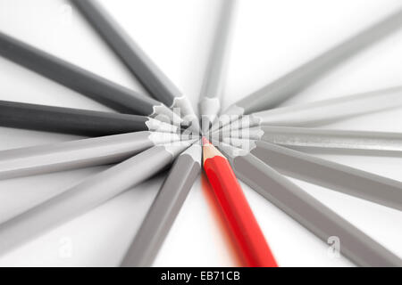 Bright red pencil standing out among gray pencils, concept of thinking differently and out of the box. On a white background wit Stock Photo