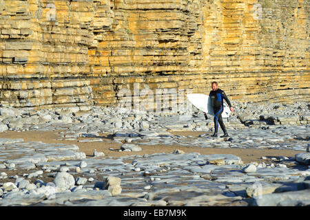 Surfer walking in wetsuit  with board on Col-huw Beach,Lantwit Major,Heritage Coast,Vale of Glamorgan,South Wales,United Kingdom Stock Photo