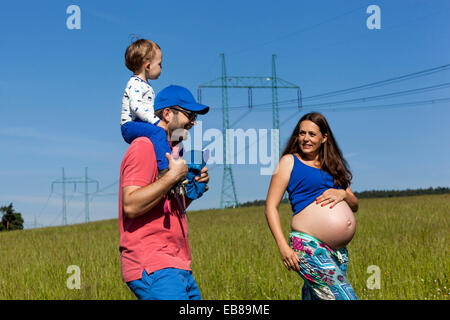 Pregnant woman walk, Family, mother, father and son Stock Photo