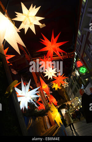 Munich, Germany. 27th Nov, 2014. Lamps in the shape of stars hang down a booth at the Christmas Market in Munich, Germany, 27 November 2014. Photo: Andreas Gebert/dpa/Alamy Live News Stock Photo