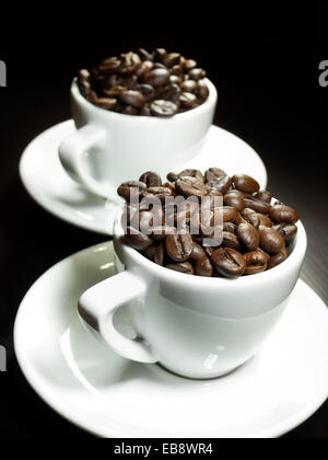 Two cups full of coffee beans. Stock Photo