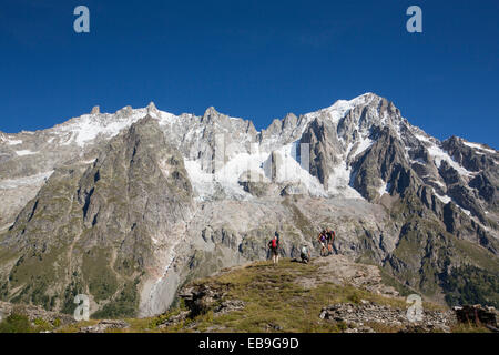 Walkers doing the Tour du Mont Blanc on Mont de la Saxe above courmayeur in Italy, looking across to the Dent Du Geant Stock Photo