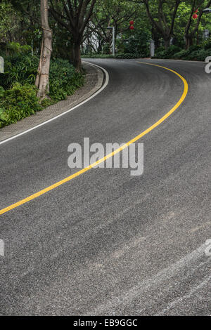 curved road with trees on both sides Stock Photo