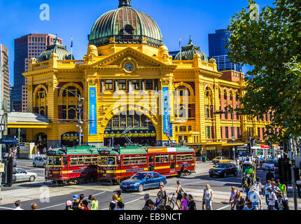 Two heritage burgundy and green trams on the free City loop in front of iconic Flinders Street Station, Melbourne, Australia Stock Photo