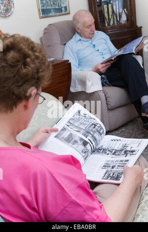 Older couple relaxing at home reading, Stock Photo