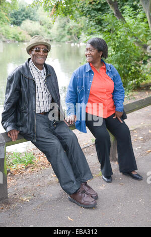 Older couple taking a break from a walk in the park together, Stock Photo