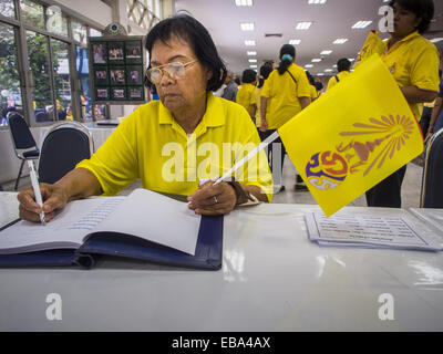 Bangkok, Bangkok, Thailand. 28th Nov, 2014. A woman at Siriraj Hospital signs a book of birthday greetings for Bhumibol Adulyadej, the King of Thailand. The King was born on December 5, 1927, in Cambridge, Massachusetts. The family was in the United States because his father, Prince Mahidol, was studying Public Health at Harvard University. He has reigned since 1946 and is the world's currently reigning longest serving monarch and the longest serving monarch in Thai history. Bhumibol, who is in poor health, is revered by the Thai people. His birthday is a national holiday and is also celebr Stock Photo