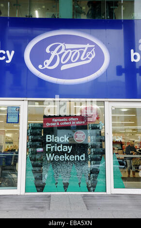 Brighton, UK. 28th Nov, 2014. Boots the Chemist store with Black Friday Weekend advertising poster Shoppers out in force in Brighton this morning for the Black Friday shopping day where stores cut their prices and offer bargains for Christmas Black Friday originates from America where stores traditionally slash their prices after Thanksgiving Photograph taken by Simon Dack/Alamy Live News Stock Photo
