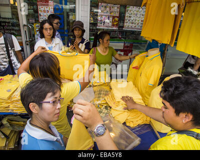 Bangkok, Bangkok, Thailand. 28th Nov, 2014. People look at yellow shirts that are sold on the streets of Bangkok before the King's Birthday. Bhumibol Adulyadej, the King of Thailand, was born on December 5, 1927, in Cambridge, Massachusetts. The family was in the United States because his father, Prince Mahidol, was studying Public Health at Harvard University. He has reigned since 1946 and is the world's currently reigning longest serving monarch and the longest serving monarch in Thai history. Bhumibol, who is in poor health, is revered by the Thai people. His birthday is a national holid Stock Photo