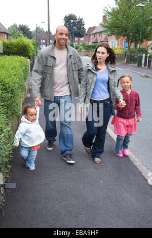 Young family walking down the street together, Stock Photo