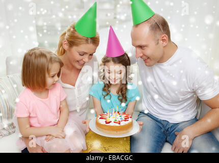 happy family with two kids in party hats at home Stock Photo