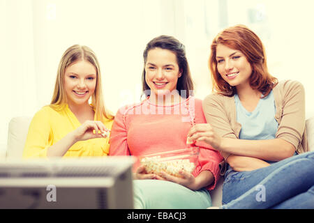 three smiling teenage girl watching tv at home Stock Photo