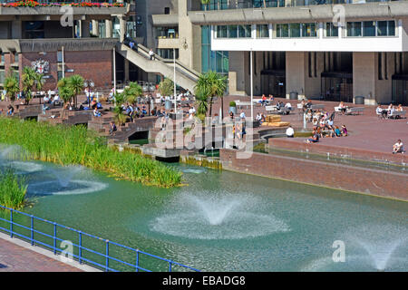 Lake & water feature fountains beside leisure terraces in urban Barbican Centre surrounded by estate of high apartment homes City of London England UK Stock Photo