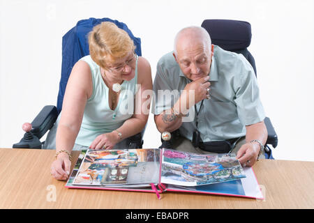 Disabled couple looking through a photo album together, Stock Photo