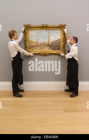 Sotheby's London, UK. 28th Nov, 2014. Sotheby's hold a preview for their December 3rd sale of Old Master and British Paintings at their Bond Street gallery. The exhibition runs from November 29th to December 3rd. PICTURED: Sotheby's gallery technicians hang Canaletto's Venice, the Piazza San Marco Looking East Towards the Basillico, which is expected to fetch up to £7 million at auction. Credit:  Paul Davey/Alamy Live News Stock Photo