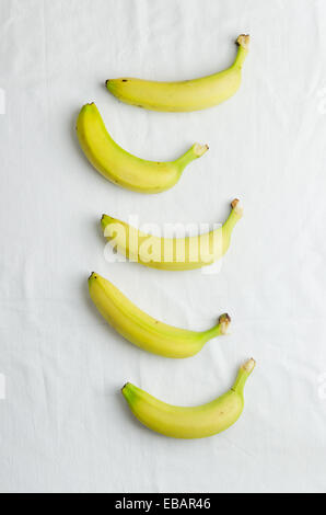 Multiple bananas over white cloth, above view Stock Photo