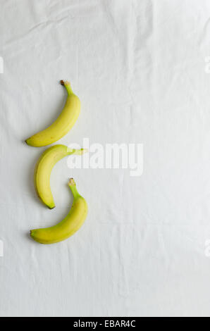 Multiple bananas over white cloth, above view Stock Photo