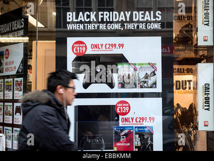 Glasgow, Scotland, UK. 28th November, 2014. Shoppers are pictured walking past 'Black Friday' advertising in shop windows on Buchanan Street in Glasgow on November 28, 2014. Police blasted stores for bringing 'Black Friday' to Britain, with the US sales event descending into chaotic fist fights as frenzied consumers battled to grab discounted goods. In scenes of pandemonium around the country. Credit:  Sam Kovak/Alamy Live News Stock Photo