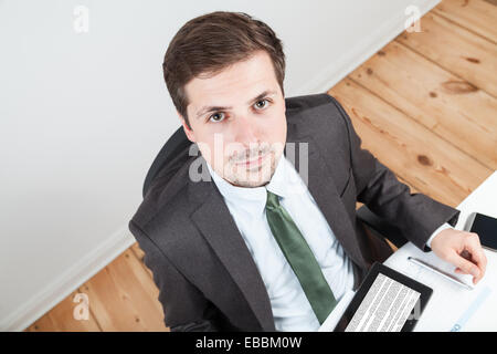businessman in office with tablet on desk Stock Photo