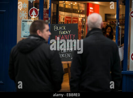 Glasgow, Scotland, UK. 28th November, 2014. Shoppers are pictured walking past 'Black Friday' advertising in shop windows on Buchanan Street in Glasgow on November 28, 2014. Police blasted stores for bringing 'Black Friday' to Britain, with the US sales event descending into chaotic fist fights as frenzied consumers battled to grab discounted goods. In scenes of pandemonium around the country. Credit:  Sam Kovak/Alamy Live News Stock Photo