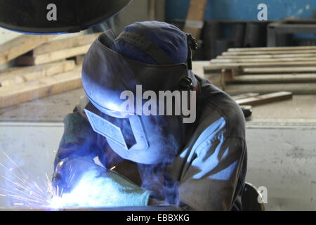 Industrial welder welding on steel in factory Stock Photo