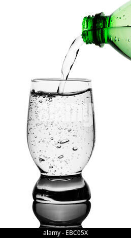Top view of mineral water being poured into glass from green bottle. isolated clipping paths Stock Photo