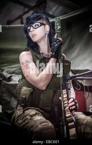A young female dressed in protective safety clothing for airsoft games with her military style gun. Stock Photo