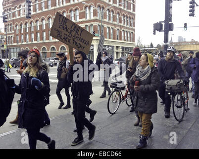 Chicago, Illinois, USA. 28th Nov, 2014. Protesters of the shooting of 18 year old black youth Michael Brown by police officer Darren Wilson in Ferguson, Missouri show their dissent by marching in front of retail stores on the major shopping day following Thanksgiving (Black Friday). The group in this picture marched by the Apple store on North Avenue in Chicago. They were chanting, ''Hands up, don't shoot.'' as they walked past the store. Some of the protesters displayed signs voicing their objections. Credit:  Karen I. Hirsch/ZUMA Wire/ZUMAPRESS.com/Alamy Live News Stock Photo