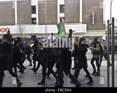 Chicago, Illinois, USA. 28th Nov, 2014. Protesters of the shooting of 18 year old black youth Michael Brown by police officer Darren Wilson in Ferguson, Missouri show their dissent by marching in front of retail stores on the major shopping day following Thanksgiving (Black Friday). The group in this picture marched by the Apple store on North Avenue in Chicago. They were chanting, ''Hands up, don't shoot.'' as they walked past the store. Some of the protesters displayed signs voicing their objections. Credit:  Karen I. Hirsch/ZUMA Wire/ZUMAPRESS.com/Alamy Live News Stock Photo