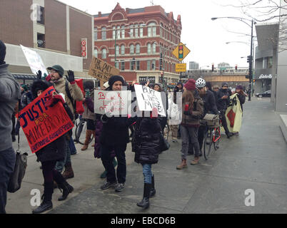 Chicago, Illinois, USA. 28th Nov, 2014. Protesters of the shooting of 18 year old black youth Michael Brown by police officer Darren Wilson in Ferguson, Missouri show their dissent by marching in front of retail stores on the major shopping day following Thanksgiving (Black Friday). The group in this picture marched by the Apple store on North Avenue in Chicago. They were chanting, ''Hands up, don't shoot.'' as they walked past the store. Some of the protesters displayed signs voicing their objections. Credit:  Karen I. Hirsch/ZUMA Wire/ZUMAPRESS.com/Alamy Live News Stock Photo