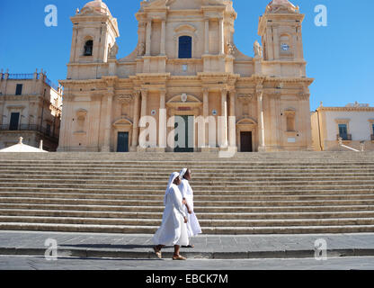 Two nuns walking in front of a church in Noto, Sicily, Italy. Stock Photo