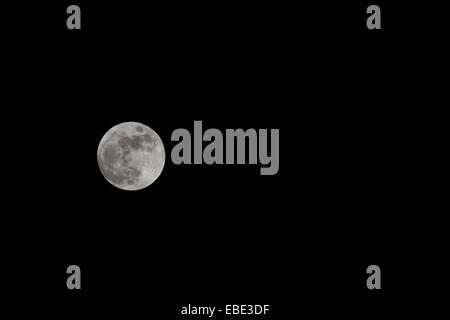 Full moon in dark night sky with large copy space, detailed lunar surface visible in minimalist astronomy and night sky scene Stock Photo