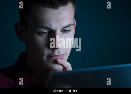 Young Man looking at Tablet Computer, Studio Shot Stock Photo